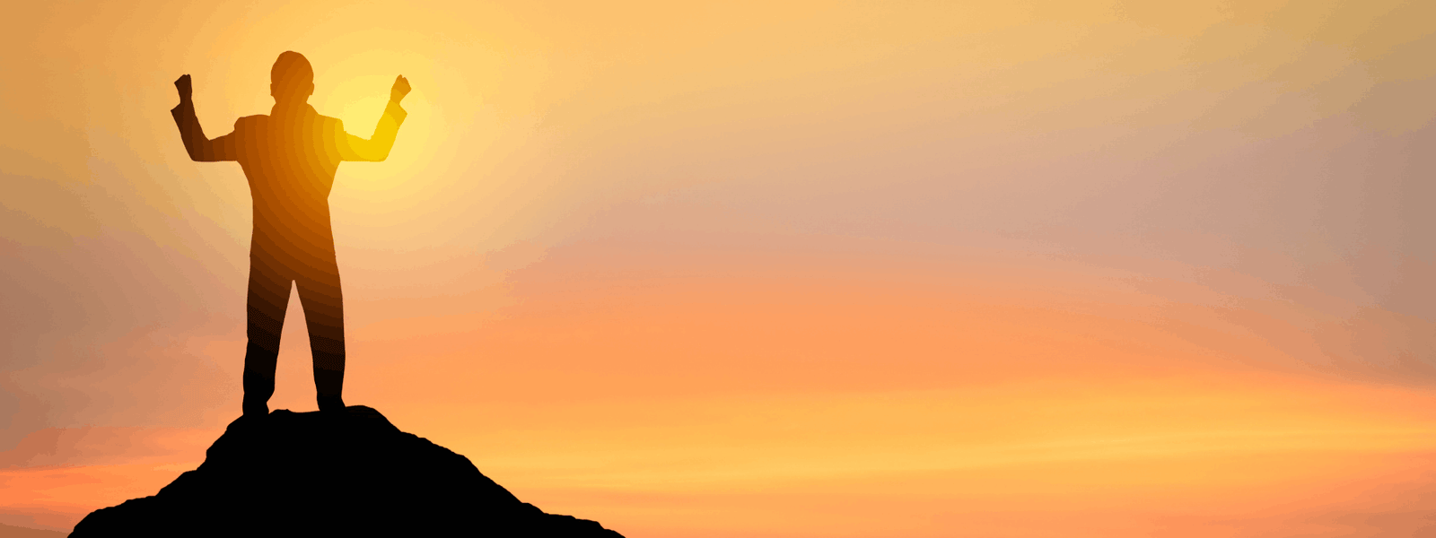 Personne les bras levés au sommet d'une colline au coucher du soleil, symbole de dépassement de soi