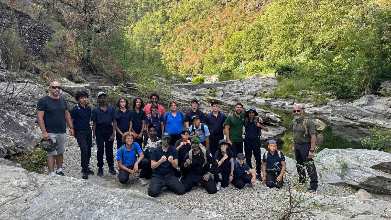 Photo de groupe du Camp Immersion Mission Alpha : les jeunes et leurs instructeurs au bord de la rivière, dans les gorges des Cévennes